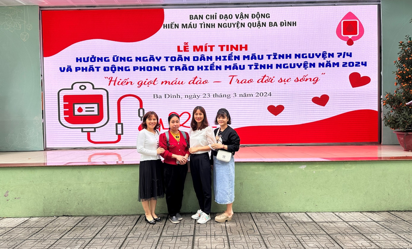 A group of women standing in front of a sign

Description automatically generated